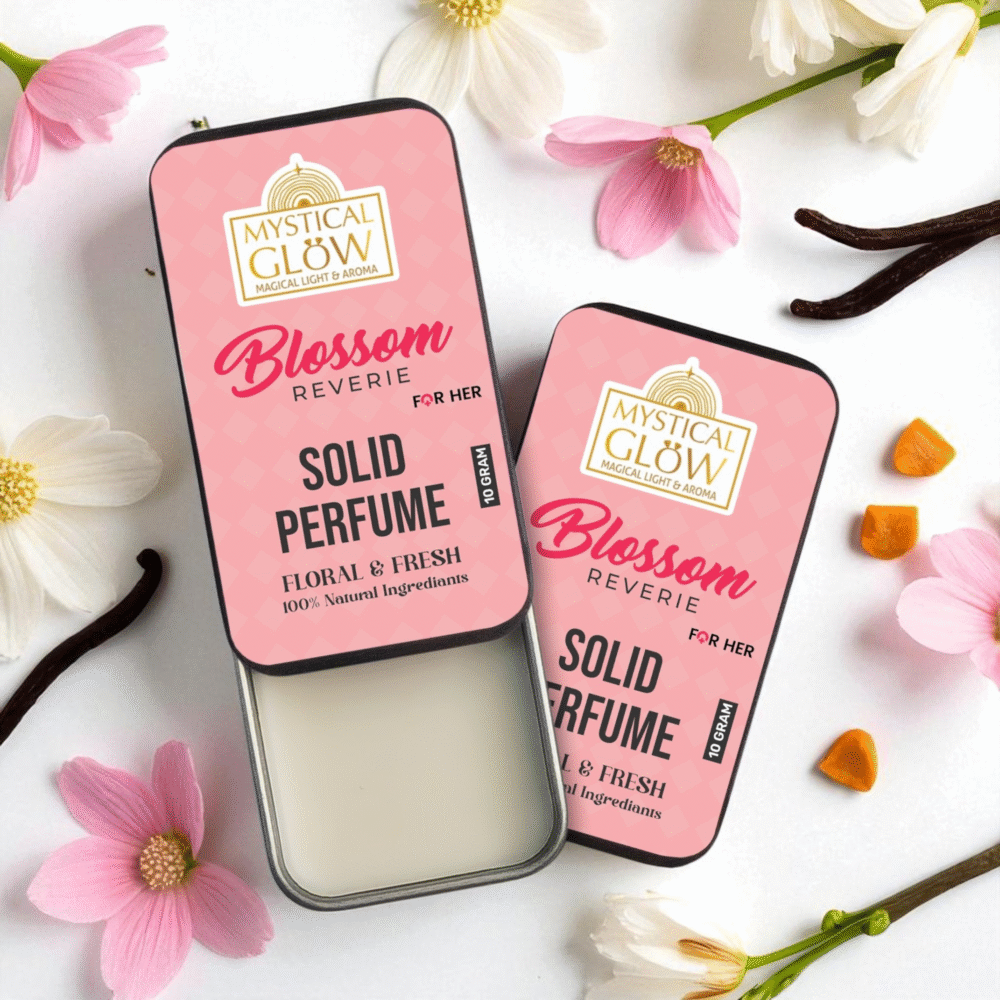 Solid Perfume for Women; Blossom Reverie solid perfume tin surrounded by blooming pink and white flowers on pastel background.
