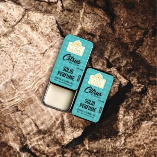 citrus-bloom-pocket-use.jpg Woman smiling in sunlight with Citrus Bloom perfume in hand, expressing freshness and vitality.