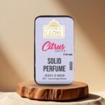 Citrus Spice Solid Perfume tin placed aesthetically on a wooden round base with natural light.