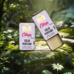 Compact Citrus Spice solid perfume tin shown with travel bag and wallet to highlight its portable design.