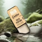 Woman applying Golden Serenity solid perfume on wrist using finger from portable tin.