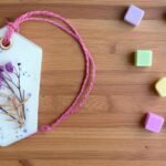 festive wax sachets for gifting placed in a gift basket with other home fragrance items